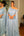 Vestido azul Serenity detalhe ombro a ombro, com flores e plumas