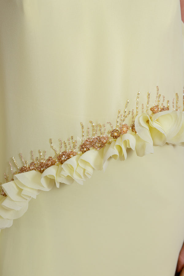 Vestido um ombro, capa longa com flores e bordados aplicados na barra da capa